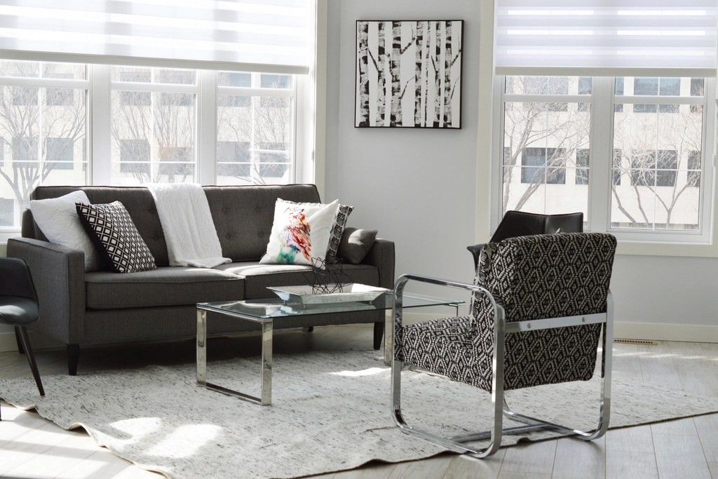 A bright, well-staged living room with large windows and morning light